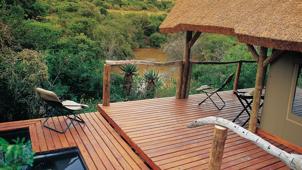Wooden deck overlooking water at Bayethe Lodge