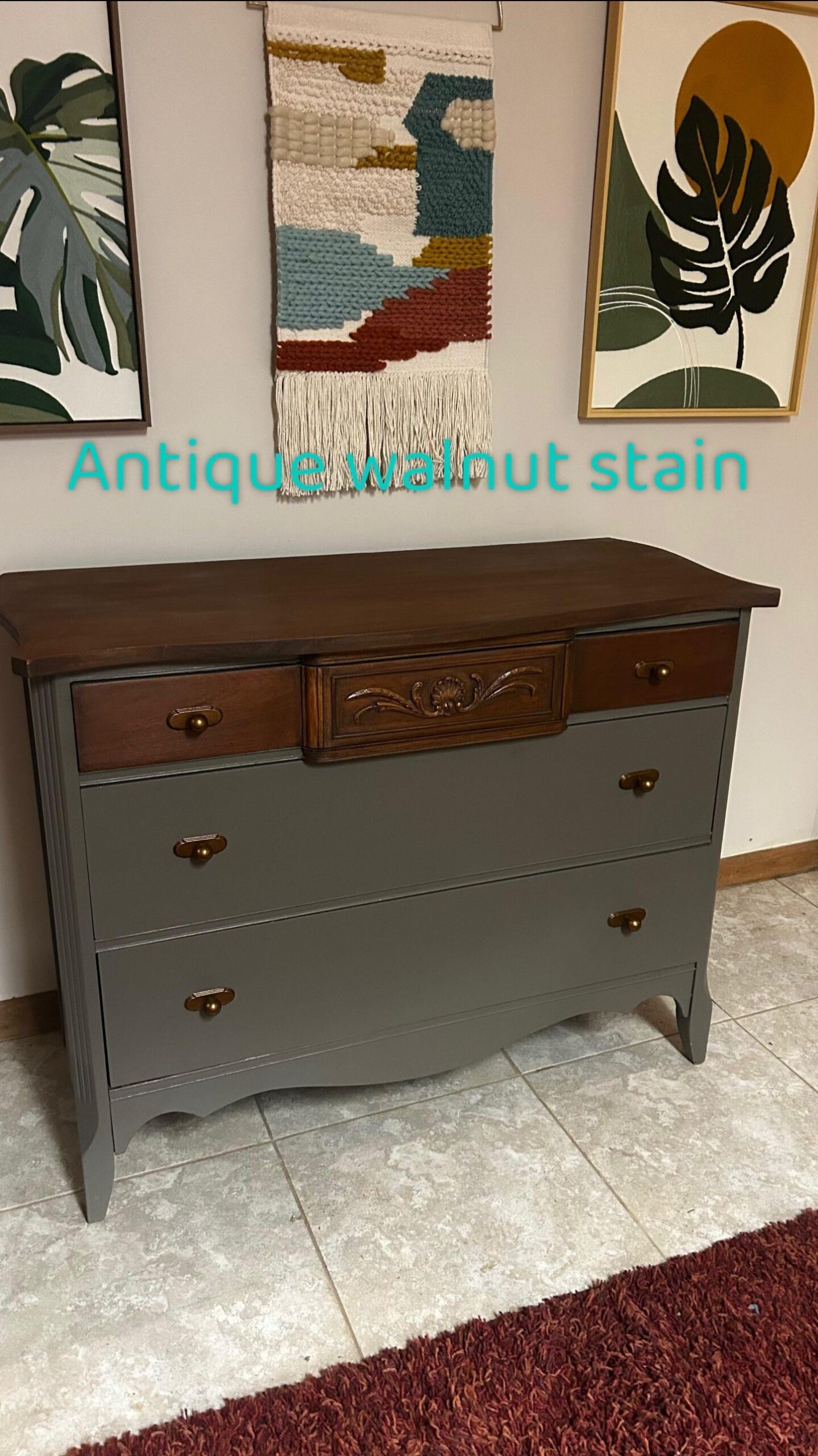The same refinished bow-front dresser now with a warm antique walnut stain on the top and carved center drawer, paired with the olive-gray body and brass pulls.