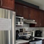 She sprayed cherry cabinets Chantilly Lace with Sherwin-Williams Gallery Series: same navy island, new kitchen