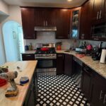 He sprayed dark cherry cabinets Benjamin Moore Rosepine: same checkered floor, now the kitchen looks custom