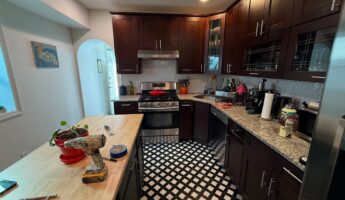 He sprayed dark cherry cabinets Benjamin Moore Rosepine: same checkered floor, now the kitchen looks custom