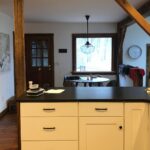 They replaced white Shaker cabinets with Hale Navy and marble: now the exposed-beam kitchen looks custom