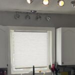 They kept their rustic backsplash and added Benjamin Moore Chantilly Lace Shaker doors: now the kitchen looks custom