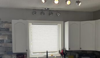 They kept their rustic backsplash and added Benjamin Moore Chantilly Lace Shaker doors: now the kitchen looks custom