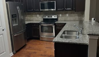 She kept every dark raised-panel cabinet and painted them Sherwin-Williams Naval: now it looks custom