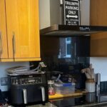 They sprayed their orange oak cabinets Cashmere Satin and kept the black granite: now the kitchen looks custom-built