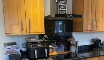 They sprayed their orange oak cabinets Cashmere Satin and kept the black granite: now the kitchen looks custom-built