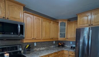 She painted honey oak cabinets Benjamin Moore Revere Pewter: same arched doors, a new kitchen