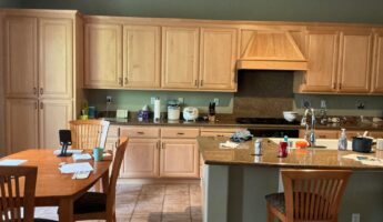 She refused bright white cabinets in her sage green kitchen: dark walnut made the room look custom