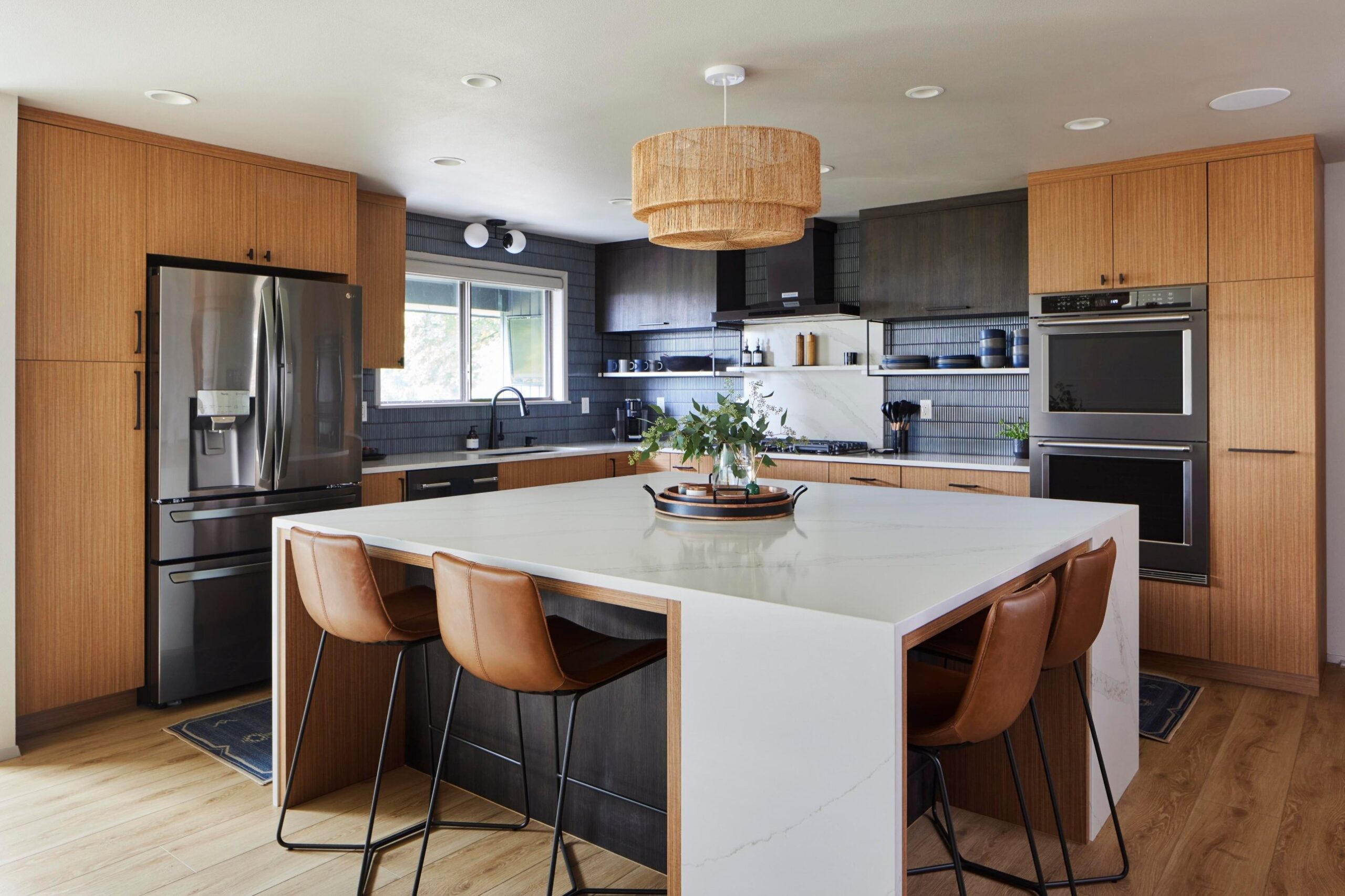 Teak Cabinets with Dark Blue Tile and Waterfall Island (After) | Credit: @ModelRemodel