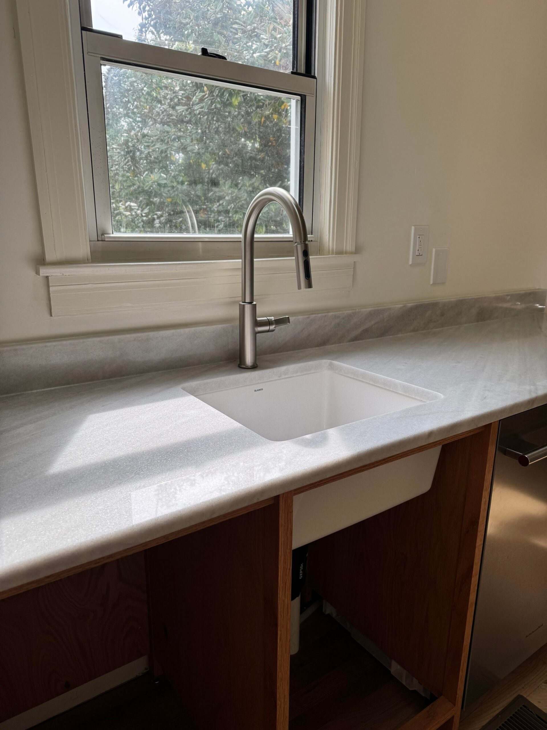 Angled view of the finished marble counter with the undermount sink dropped in, before any drawer fronts have been installed.